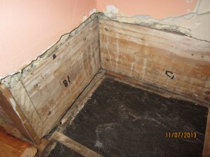 Chipped out tile grout. We plan to restore the hardwood floor here.